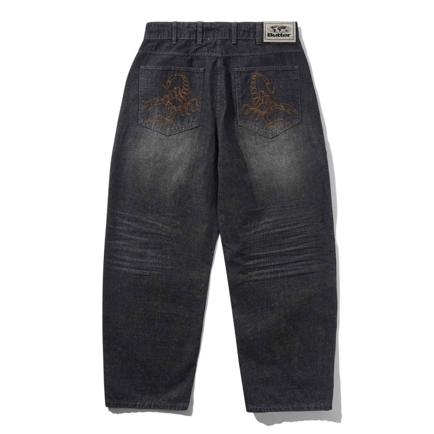 Black distressed jeans with embroidery on a white background