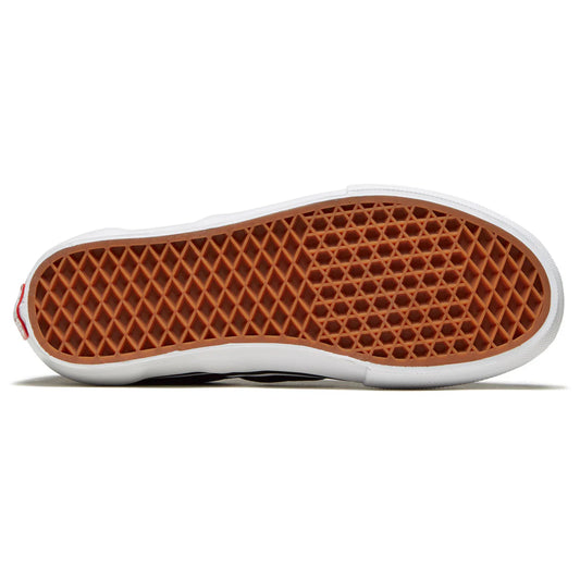 Close-up of a shoe sole with brown waffle pattern on a white background