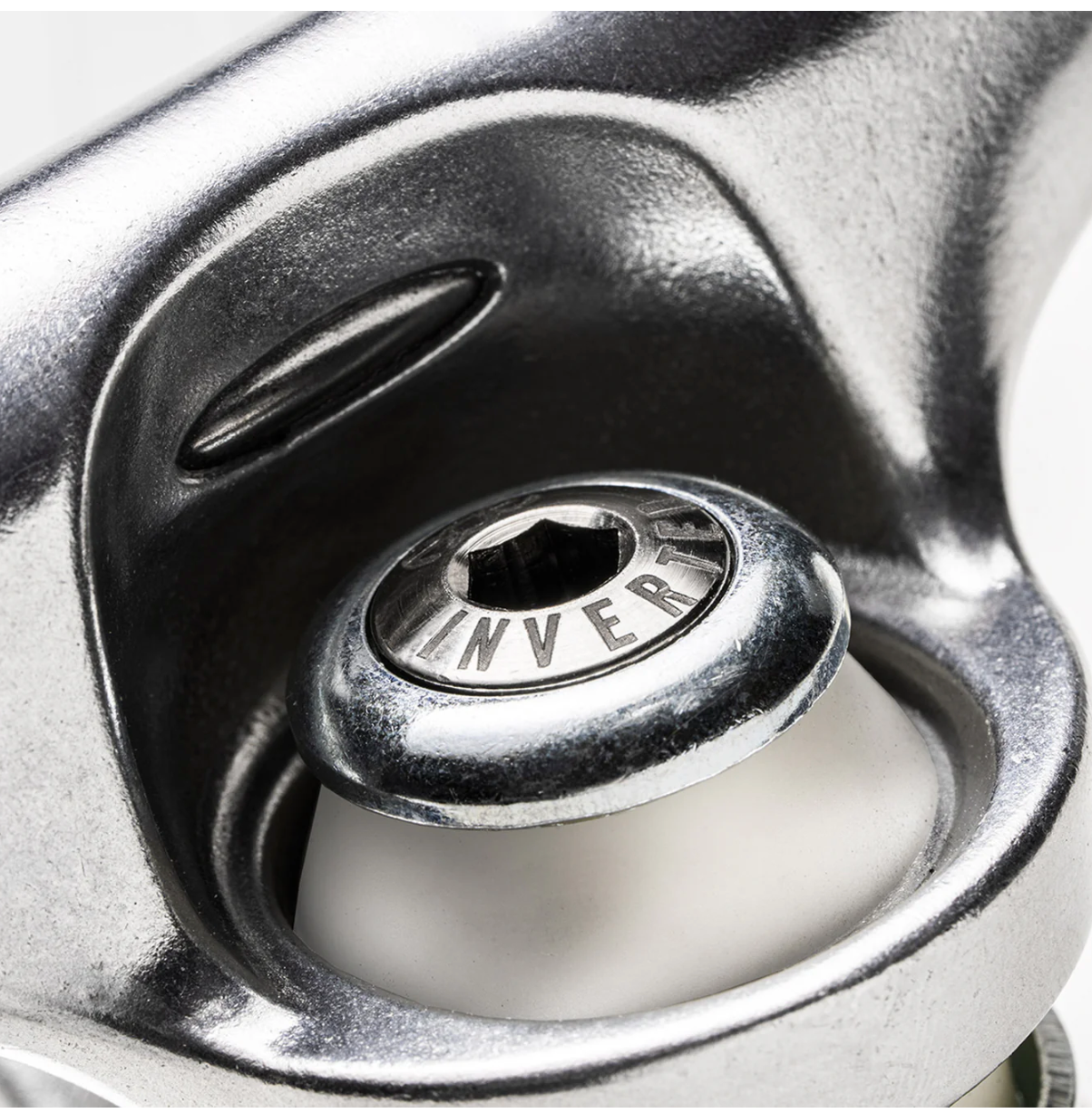 Close-up of a metallic sink drain with 'Inverted' branding.