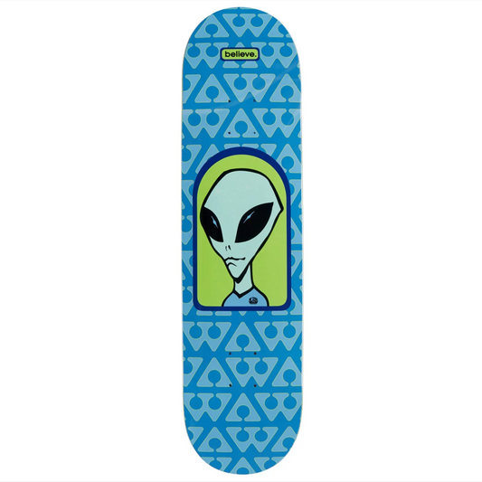 A skateboard deck featuring a blue and light blue geometric pattern background with a central graphic of a green alien head. The brand name 'Believe' is printed in a yellow box near the top.