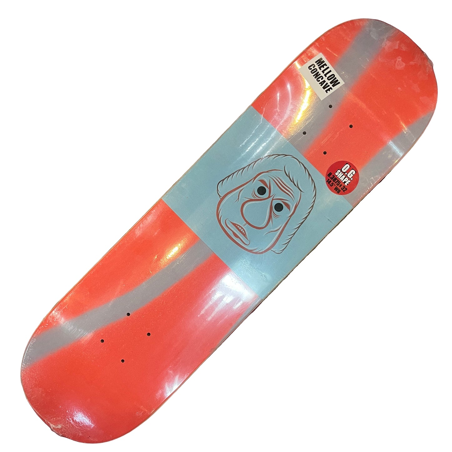 Skateboard deck with a face design on a red and beige patterned surface