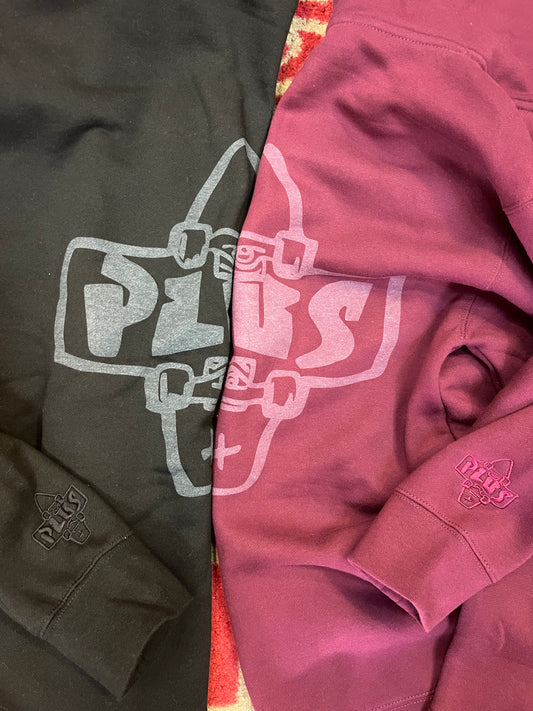 Two hoodies, one pink and one green, with a robot graphic design on a colorful background.