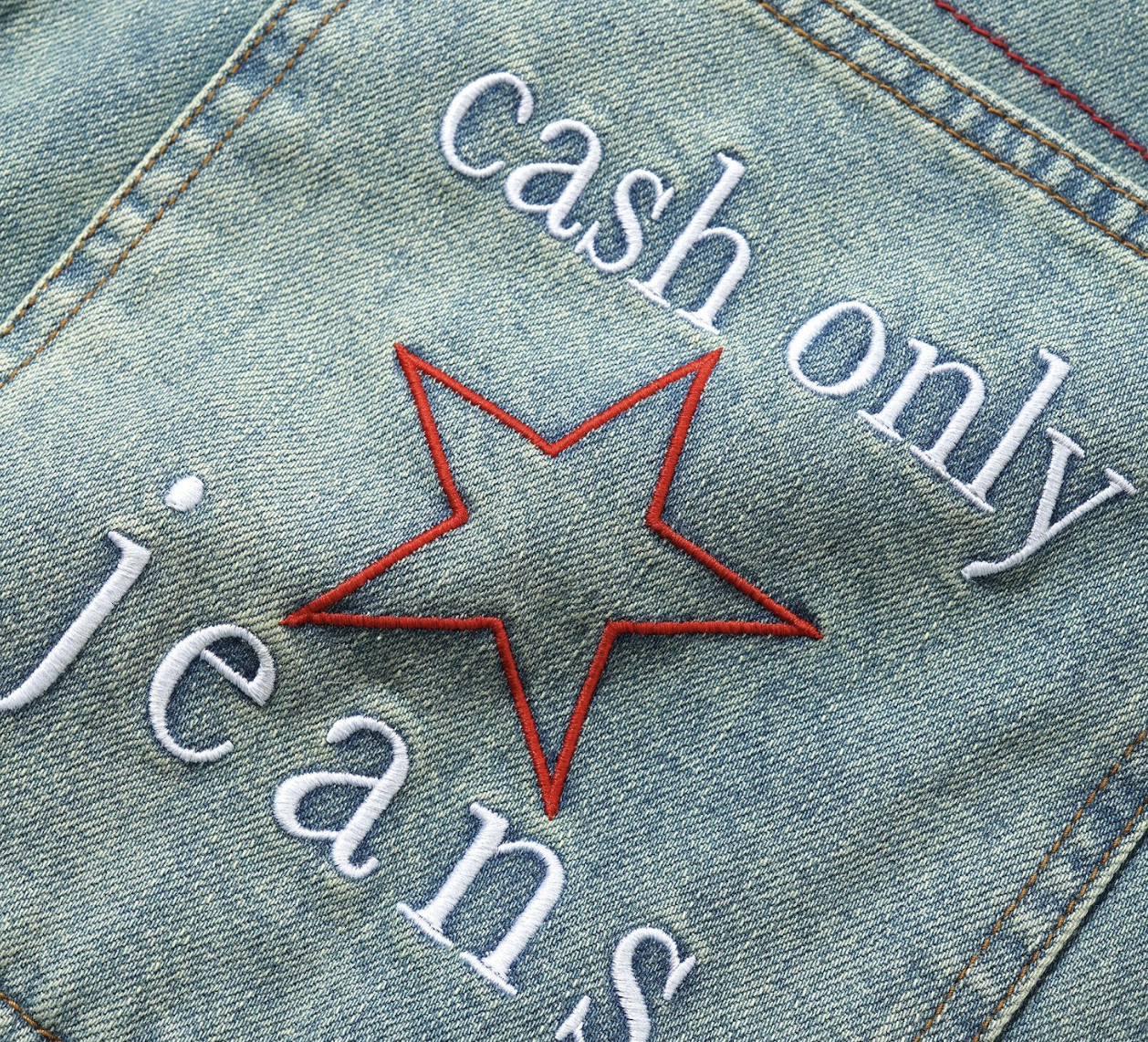 Denim jacket with 'cash only jeans' text and red star design.