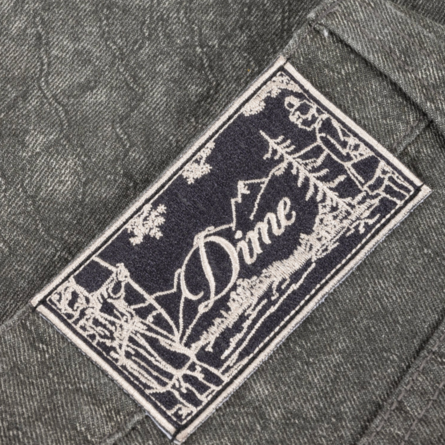 Close-up of a 'Dime' brand label on a textured fabric background