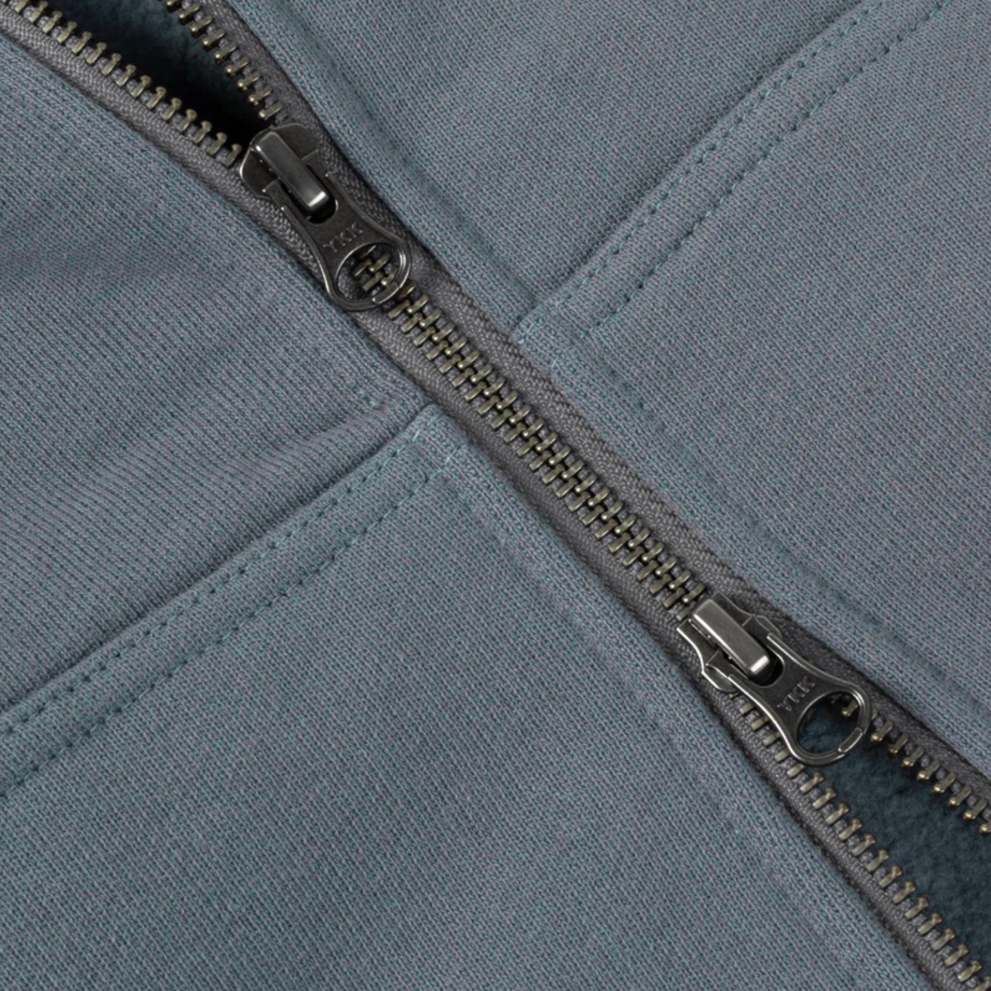 Close-up of a zipper on a gray fabric surface