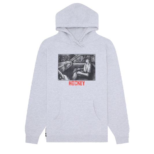A light heather gray pullover hoodie with a front kangaroo pocket and a central graphic print. The graphic features a black and white illustration of a hockey player in a car, with the word 'HOCKEY' printed below in red.