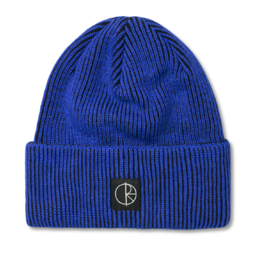 A royal blue ribbed knit beanie hat with a black square patch on the front cuff featuring a white stylized logo, shown against a plain white background.