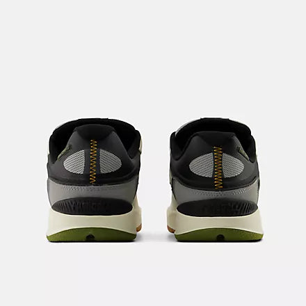 A pair of black and gray athletic sneakers shown from the back, featuring a cream midsole and olive green outsole.