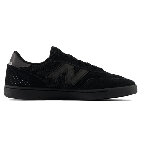 Black sneaker with green accents on a white background