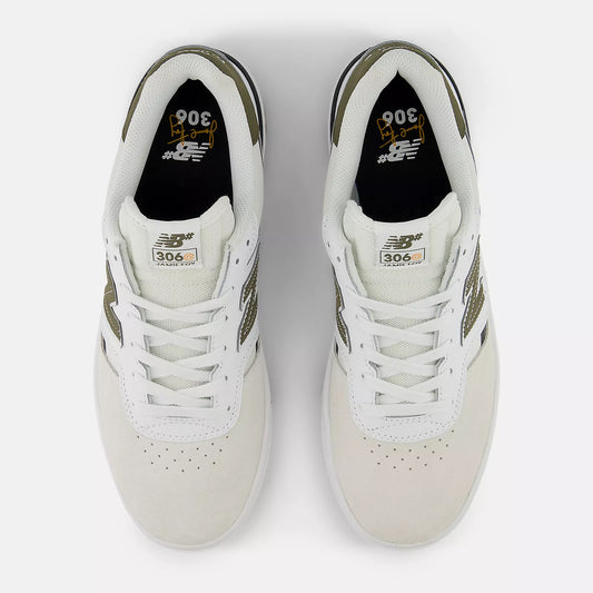 Pair of white sneakers with green accents on a light gray background