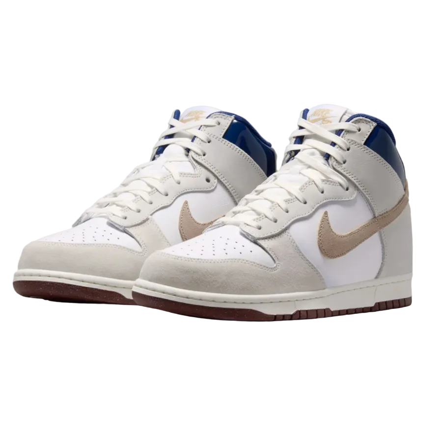 A pair of Nike Dunk High sneakers in white, beige, and navy blue, featuring a beige Swoosh and a navy blue collar, shown on a white background.