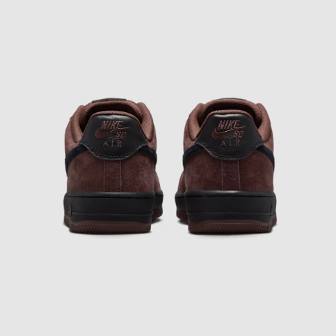 A pair of Nike Air Force 1 Low sneakers shown from the back, featuring dark brown suede with black heel tabs and black soles