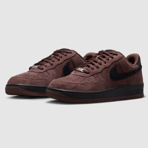 A pair of Nike Air Force 1 Low sneakers in a dark brown suede featuring a black Swoosh and black midsole