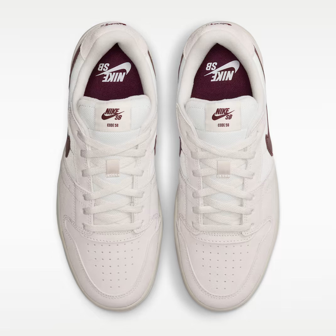 A pair of Nike Air Force 1 Low sneakers shown from a top-down view. The shoes are primarily off-white with a deep burgundy accent on the inner lining and heel tab, featuring the classic white Swoosh and 'AIR FORCE 1' text.