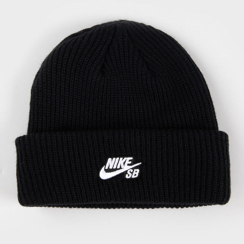 A black ribbed knit beanie hat with a white embroidered Nike SB logo on the front cuff, shown against a plain light gray background.