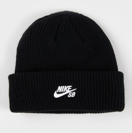 A black ribbed knit beanie hat with a white embroidered Nike SB logo on the front cuff, shown against a plain light gray background.
