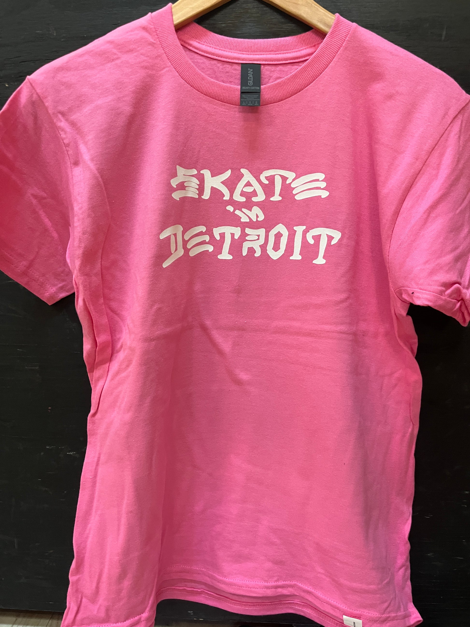 Pink t-shirt with 'Skate Detroit' text on a dark background