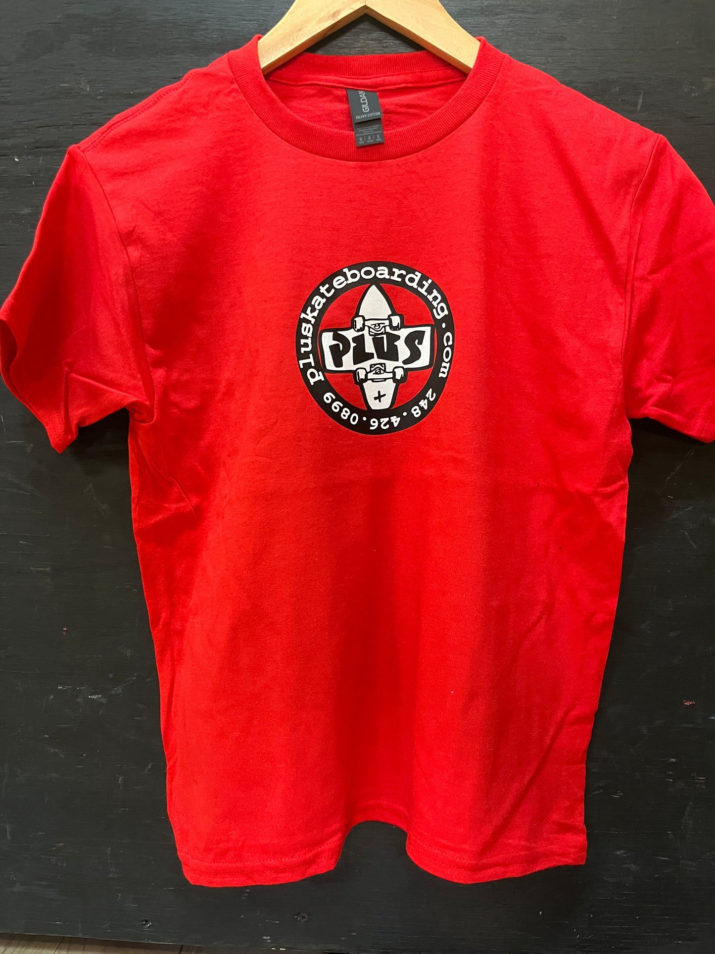 Red t-shirt with a logo on a black surface