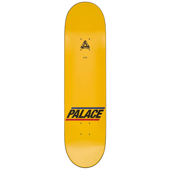 A yellow skateboard deck shown vertically against a plain white background, featuring the Palace brand name in black with red and blue stripes near the bottom.
