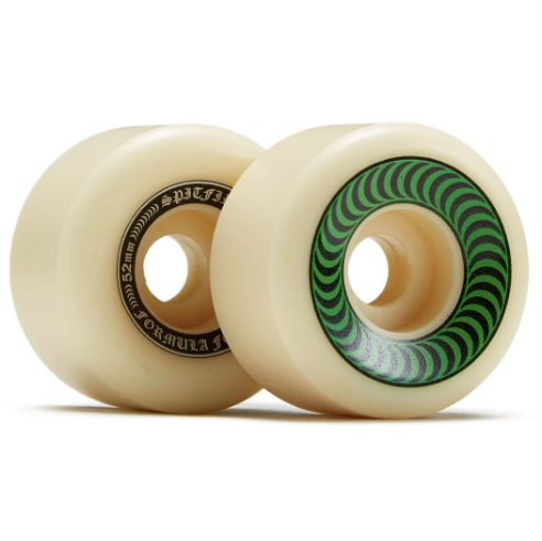 Two cream-colored skateboard wheels with a green and black spiral pattern on the inner ring