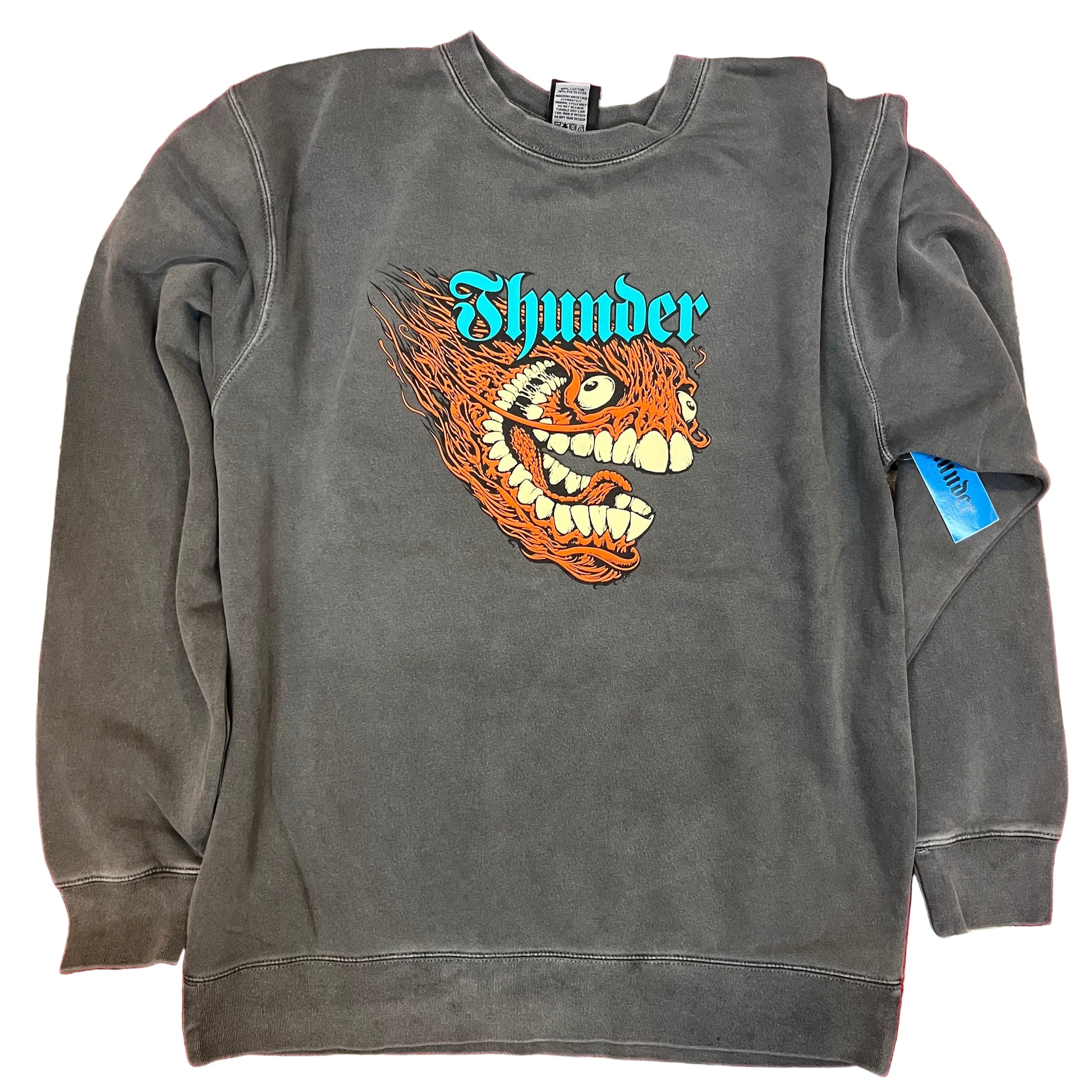 Gray sweatshirt with a graphic design and 'Thunder' text on a red and beige patterned background