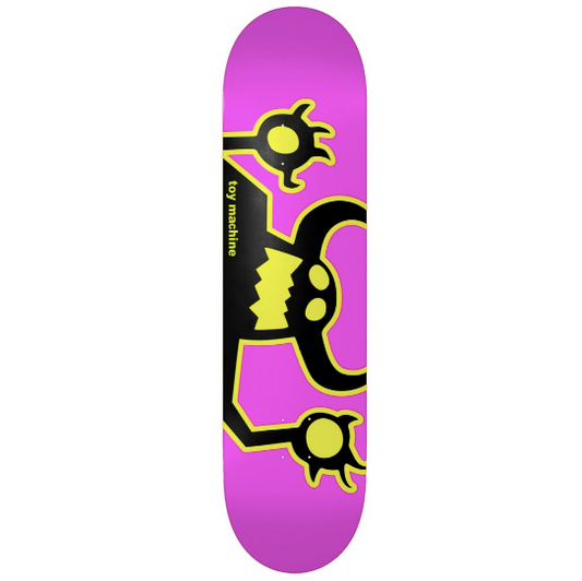 A skateboard deck with a bright magenta pink background, featuring a black and neon yellow cartoon monster graphic and the text 'toy machine' printed vertically on the side.