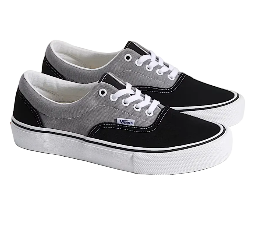 Pair of black and gray Vans sneakers on a light background