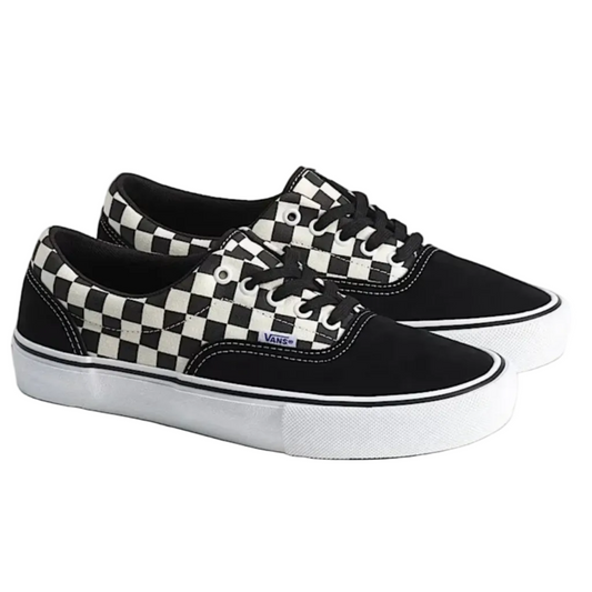 A pair of Vans low-top sneakers in black and white checkerboard canvas and black suede, featuring white rubber soles.