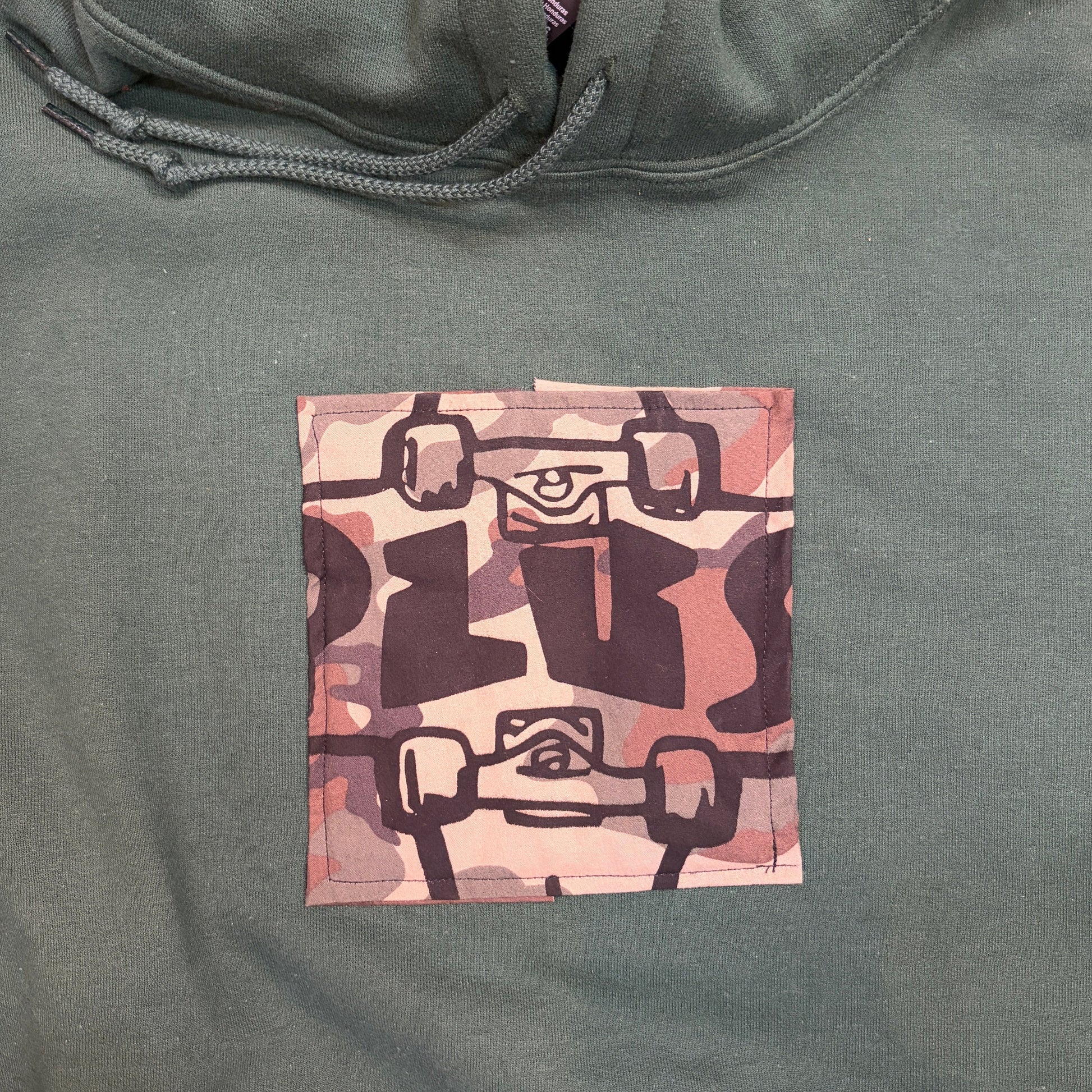 Green hoodie with a camo plus logo patch